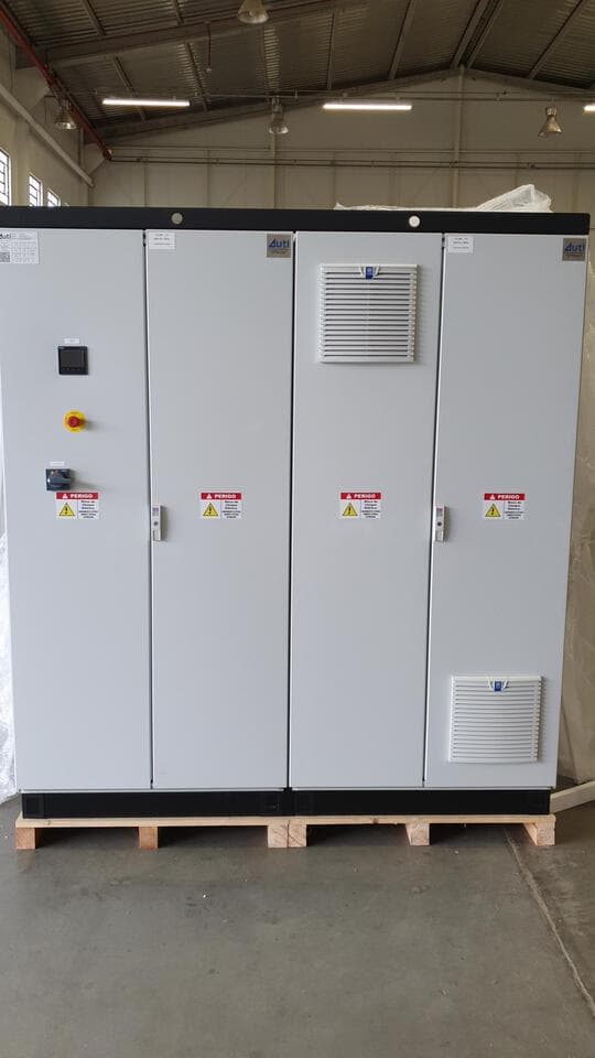 Panel eléctrico gris de cuatro puertas con ventilación sobre palé en nave