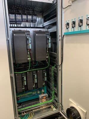 Interior de panel con dos accionamientos negros grandes y cableado verde