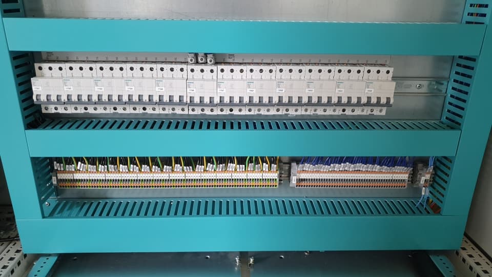 Minidisyuntores Siemens y bornes con cables identificados en estructura turquesa