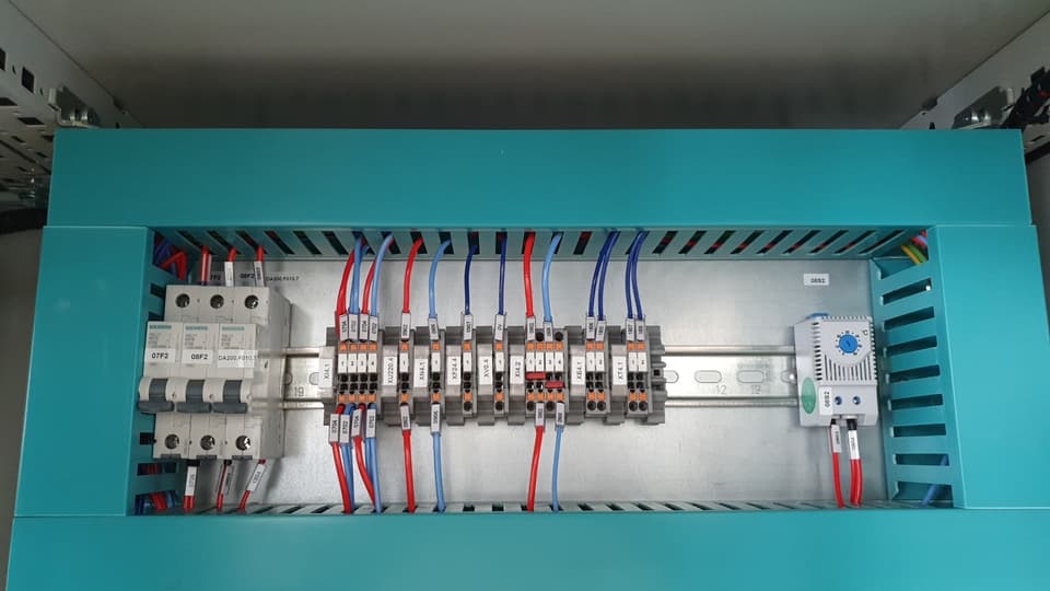 Bornes con cables de colores, minidisyuntores Siemens y termostato en riel DIN
