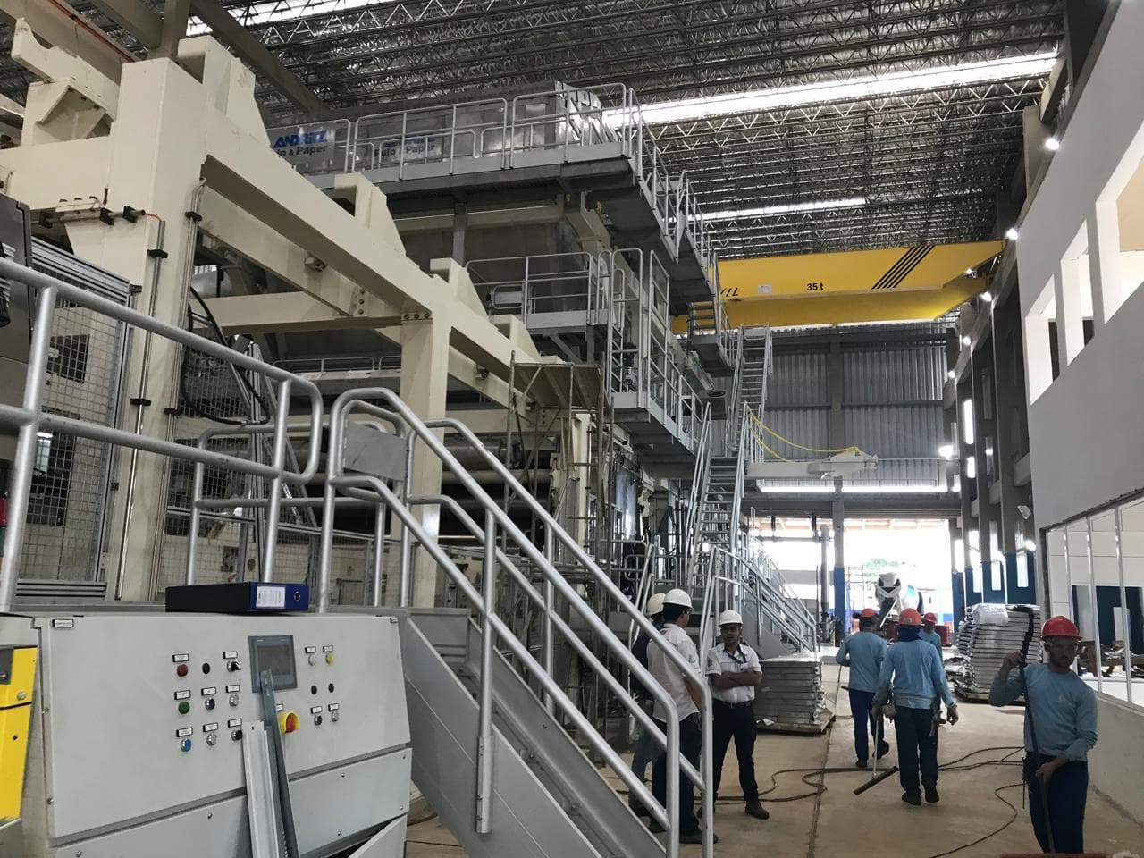 Máquina industrial Andritz con pasarelas, panel de mando y equipo con casco