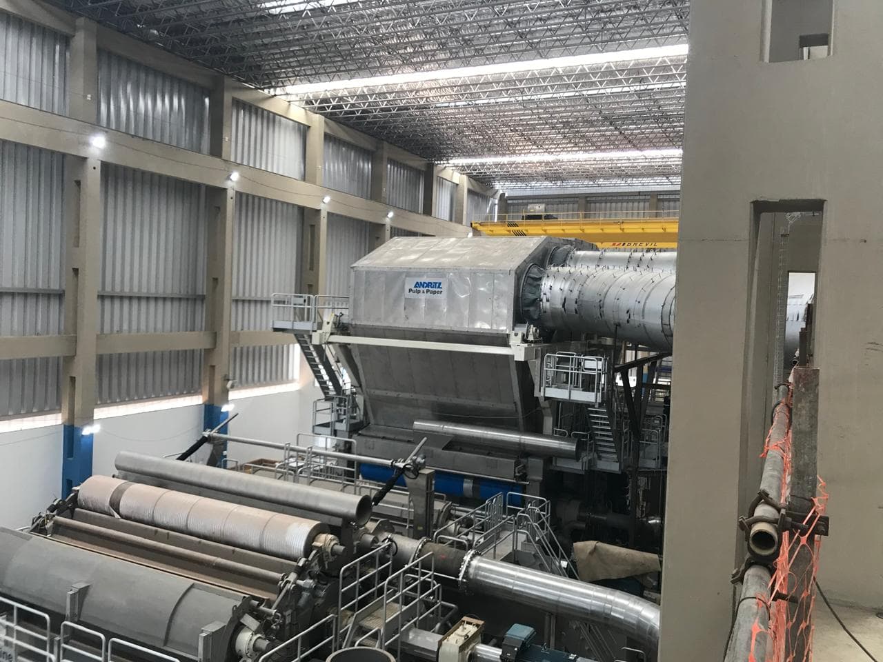 Máquina industrial Andritz Pulp & Paper con ductos, vista de nave alta