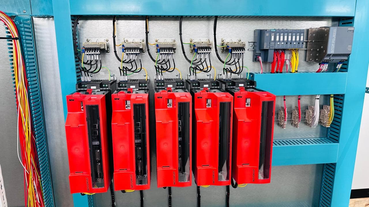 Cinco accionamientos SEW MOVIDRIVE rojos en panel con fuente SITOP